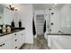 Bathroom featuring dual vanities, a walk-in shower, and a soaking tub with modern fixtures at 6506 Merrimack Dr, Castle Pines, CO 80108