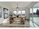 Bright dining room with a wooden table, modern light fixture, and sliding glass doors to the patio at 6506 Merrimack Dr, Castle Pines, CO 80108