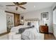 Bright main bedroom with a ceiling fan, wood floors, a sliding barn door, and ensuite bathroom at 6506 Merrimack Dr, Castle Pines, CO 80108