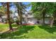 The backyard features a lush green lawn, mature trees, and a deck at 4505 S Yosemite St # 125, Denver, CO 80237