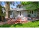 The house's backyard features a stone chimney, a deck, and a lush green lawn at 4505 S Yosemite St # 125, Denver, CO 80237