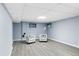 Finished basement with gray walls and flooring, white armchairs, and modern lighting at 4505 S Yosemite St # 125, Denver, CO 80237