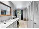 Bright bathroom featuring double sinks, a big mirror, and closet for storing towels at 4505 S Yosemite St # 125, Denver, CO 80237