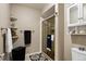 Bathroom featuring glass enclosed shower, storage cabinet, floating shelves, and black and white accents at 4505 S Yosemite St # 125, Denver, CO 80237