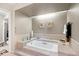 Luxurious bathroom featuring a large soaking tub, tile surround, and natural light at 4505 S Yosemite St # 125, Denver, CO 80237