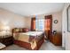 Bedroom featuring neutral paint, carpet, traditional furniture, and a window with orange curtains at 4505 S Yosemite St # 125, Denver, CO 80237