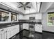 Modern kitchen with white cabinets, black countertops, stainless steel appliances, and black tile flooring at 4505 S Yosemite St # 125, Denver, CO 80237