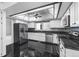 Modern kitchen with white cabinets, black countertops, stainless steel appliances, and black tile flooring at 4505 S Yosemite St # 125, Denver, CO 80237