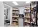 Well-organized pantry with shelving, mini-fridge, and storage for food items at 4505 S Yosemite St # 125, Denver, CO 80237