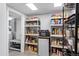 Organized pantry with shelving, mini-fridge, microwave and door to additional storage space at 4505 S Yosemite St # 125, Denver, CO 80237