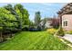 Green backyard featuring a trampoline and well-maintained lawn surrounded by mature trees and landscaping at 8410 S Oak St, Littleton, CO 80127