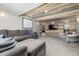 Finished basement with a rustic wood accent wall and gray sectional sofa providing a cozy entertainment area at 8410 S Oak St, Littleton, CO 80127