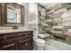 Bathroom featuring a tiled shower, wooden vanity, and framed mirror at 8410 S Oak St, Littleton, CO 80127