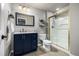 Updated bathroom with a blue vanity, white countertop, gold-framed shower, and modern fixtures at 8410 S Oak St, Littleton, CO 80127