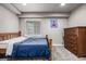 Cozy bedroom featuring light gray walls, a wooden bed frame, and a matching wooden dresser at 8410 S Oak St, Littleton, CO 80127