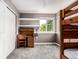 Inviting bedroom with bunk beds, ample shelving, a built-in desk, and closet for storage at 8410 S Oak St, Littleton, CO 80127