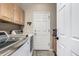 Laundry room with front-loading washer and dryer, cabinets, and a folding counter at 8410 S Oak St, Littleton, CO 80127