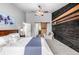Vaulted main bedroom featuring a wood accent wall, ceiling fan, and ensuite bathroom with a sliding barn door at 8410 S Oak St, Littleton, CO 80127