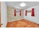 Bright bedroom featuring red curtains and brown carpet at 130 S Eaton St, Lakewood, CO 80226