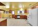 Kitchen with wood cabinets, white appliances, and yellow walls at 130 S Eaton St, Lakewood, CO 80226