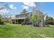 Beautiful backyard with a covered patio, lush lawn, mature trees, and outdoor seating area at 2187 Wynterbrook Dr, Highlands Ranch, CO 80126