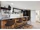 Basement bar area with custom wood paneling, a marble countertop, four stools, and a popcorn machine at 2187 Wynterbrook Dr, Highlands Ranch, CO 80126