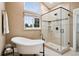 Bright bathroom featuring a freestanding tub, walk-in shower, and a window bringing in natural light at 2187 Wynterbrook Dr, Highlands Ranch, CO 80126