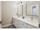 Modern bathroom with dual sinks, sleek mirrors, quartz countertop, a stylish rug, and updated fixtures at 2187 Wynterbrook Dr, Highlands Ranch, CO 80126