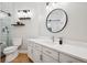 Modern bathroom features white cabinets, quartz counters, and updated fixtures, plus a round mirror and tiled shower at 2187 Wynterbrook Dr, Highlands Ranch, CO 80126