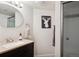 Bathroom with a wood vanity, granite countertop, oval mirror, and a glass-enclosed shower at 2187 Wynterbrook Dr, Highlands Ranch, CO 80126
