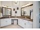 Bathroom with dual sinks, vanity, white cabinets, granite countertop, decorative lighting, and large mirrors at 2187 Wynterbrook Dr, Highlands Ranch, CO 80126