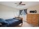 Bedroom with a blue comforter, ceiling fan, wood dresser, baseball caps decor, and natural light at 2187 Wynterbrook Dr, Highlands Ranch, CO 80126