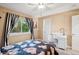 Cozy bedroom with a floral comforter, study desk and chair, and a window offering natural light at 2187 Wynterbrook Dr, Highlands Ranch, CO 80126