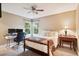 Comfortable bedroom with a desk, monitors, cushioned headboard, a ceiling fan, and plenty of natural light at 2187 Wynterbrook Dr, Highlands Ranch, CO 80126