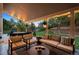 Cozy covered patio with outdoor seating, a dining area, and a view of the landscaped backyard at 2187 Wynterbrook Dr, Highlands Ranch, CO 80126