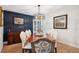 Formal dining room with dark blue accent wall, chandelier, and seating for eight at 2187 Wynterbrook Dr, Highlands Ranch, CO 80126