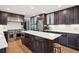 Spacious kitchen with stainless steel appliances, dark wood cabinets, white countertops, and a central island at 2187 Wynterbrook Dr, Highlands Ranch, CO 80126