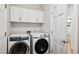 Bright laundry room with white cabinets and modern washer and dryer units at 2187 Wynterbrook Dr, Highlands Ranch, CO 80126