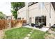 Landscaped backyard featuring green grass, a patio seating area, and a wooden fence at 2435 S High St, Denver, CO 80210