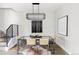 Modern dining room features a sleek glass table, unique light fixture, and staircase at 2435 S High St, Denver, CO 80210