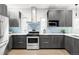Modern kitchen features stainless steel appliances, light backsplash, and sleek grey cabinetry at 2435 S High St, Denver, CO 80210