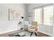 Bright office features a sleek glass desk, natural light from the window, and a decorative world map at 2435 S High St, Denver, CO 80210