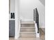 Staircase boasts light wood stairs with black railing, complementing the modern design and minimalist aesthetic at 2435 S High St, Denver, CO 80210