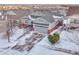 Two-story house with gray siding, two-car garage, and snowy yard at 23480 E Moraine Pl, Aurora, CO 80016