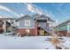 Two-story home with gray siding, brick accents, and a covered porch at 23480 E Moraine Pl, Aurora, CO 80016