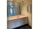Bright bathroom featuring a large mirror, white vanity, and ample cabinet space at 3131 E Alameda Ave # 604, Denver, CO 80209