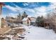 Snowy backyard with shed, raised garden beds, and arbor at 401 S Dover Ct, Lakewood, CO 80226