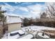 Winter backyard view, featuring a shed and raised garden beds at 401 S Dover Ct, Lakewood, CO 80226