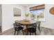 Bright dining area features a round wooden table and black chairs under a window at 12940 Brier Ct, Firestone, CO 80504