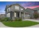 Charming two-story home featuring a covered front porch, well-manicured lawn, and a two-car garage with beautiful landscaping at 12940 Brier Ct, Firestone, CO 80504
